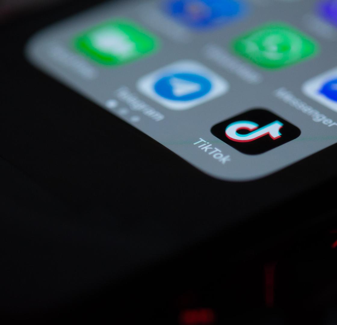 image of a lit up phone with the tiktok icons and other social media icons